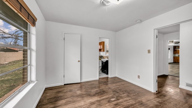 unfurnished bedroom with dark wood-type flooring and ensuite bathroom