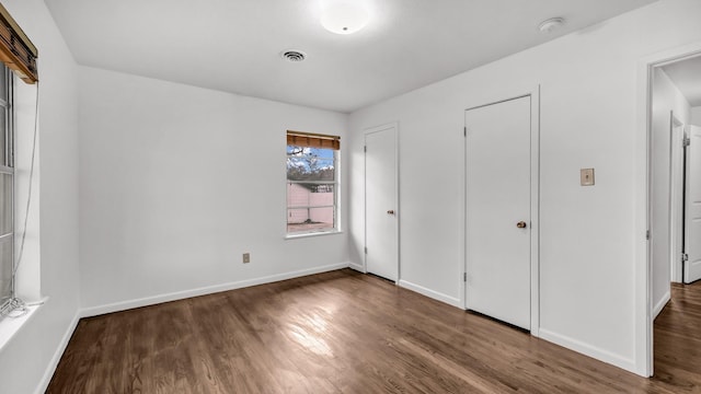 unfurnished bedroom featuring dark wood-type flooring