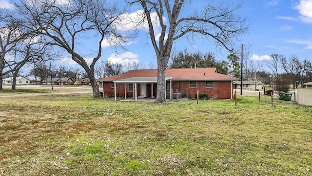 rear view of house with a patio and a lawn