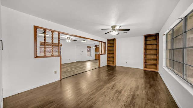 unfurnished living room featuring built in features, dark hardwood / wood-style floors, and ceiling fan