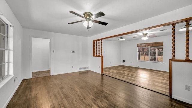 unfurnished living room with dark wood-type flooring and ceiling fan