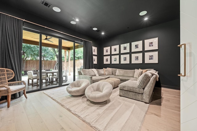 cinema featuring ceiling fan and light hardwood / wood-style flooring