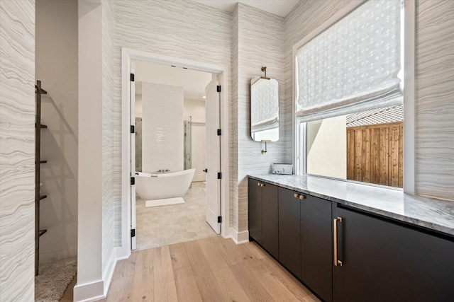 bathroom with wood-type flooring, shower with separate bathtub, and vanity