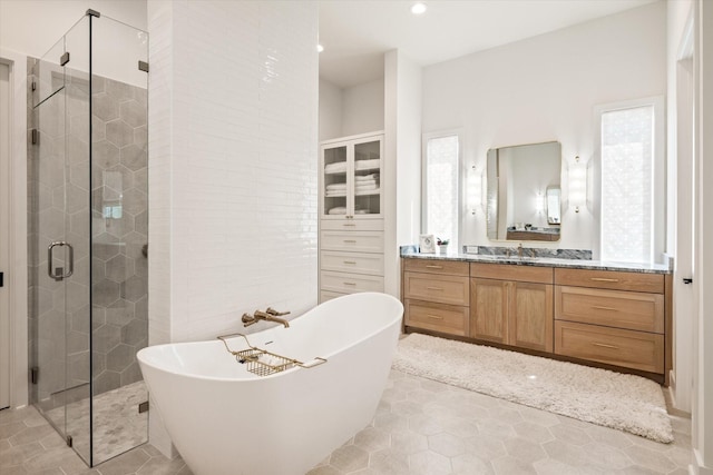 bathroom featuring vanity, tile patterned flooring, and shower with separate bathtub