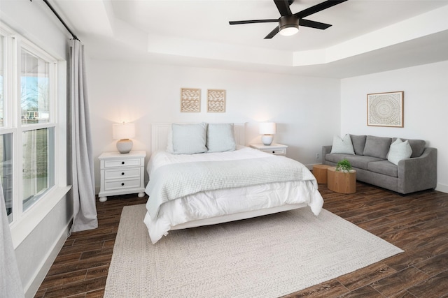 bedroom featuring a raised ceiling and ceiling fan