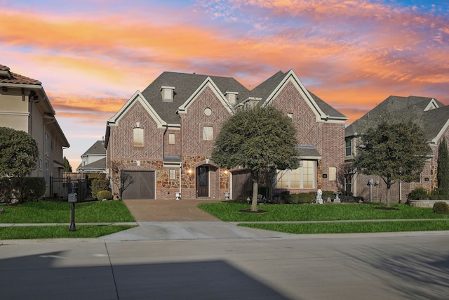 view of front of property with a garage and a lawn