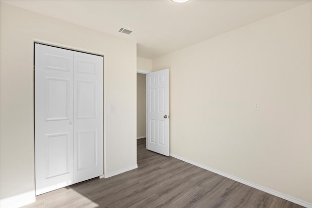 unfurnished bedroom with hardwood / wood-style flooring and a closet