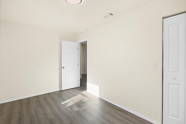 unfurnished room featuring dark wood-type flooring