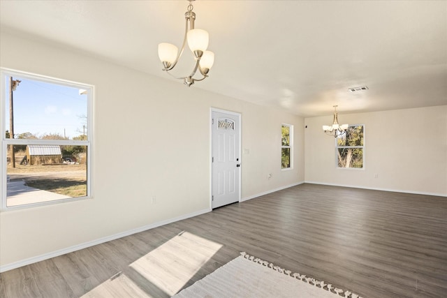 empty room featuring dark hardwood / wood-style floors and a chandelier