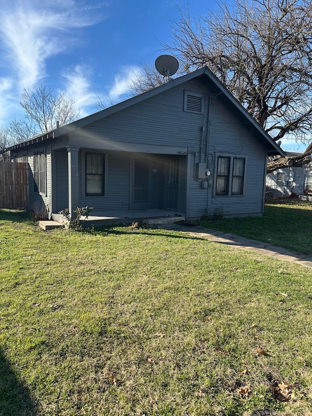 rear view of property featuring a lawn