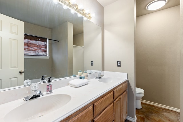 bathroom with vanity, tile patterned flooring, and toilet