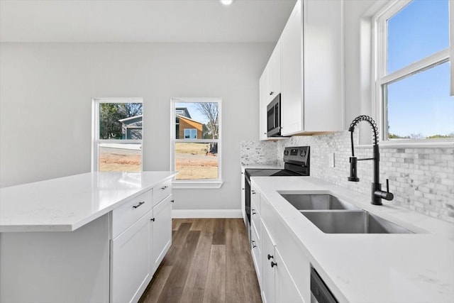 kitchen with black electric range oven, sink, white cabinets, dark hardwood / wood-style flooring, and decorative backsplash