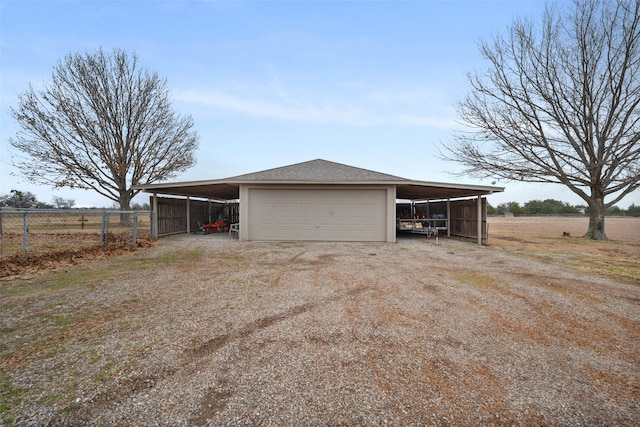 garage featuring a carport and a rural view