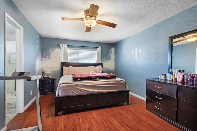 bedroom featuring ceiling fan, dark hardwood / wood-style floors, and a textured ceiling