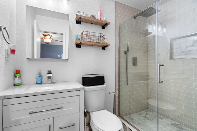 bathroom with a shower with door, vanity, and toilet