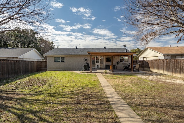 back of property with a patio area and a lawn