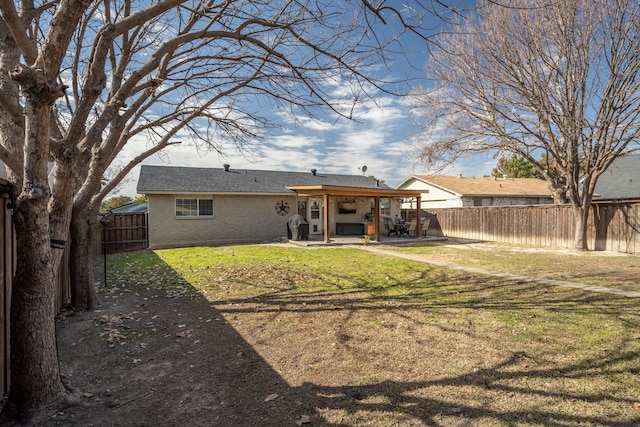 back of house with a lawn and a patio area