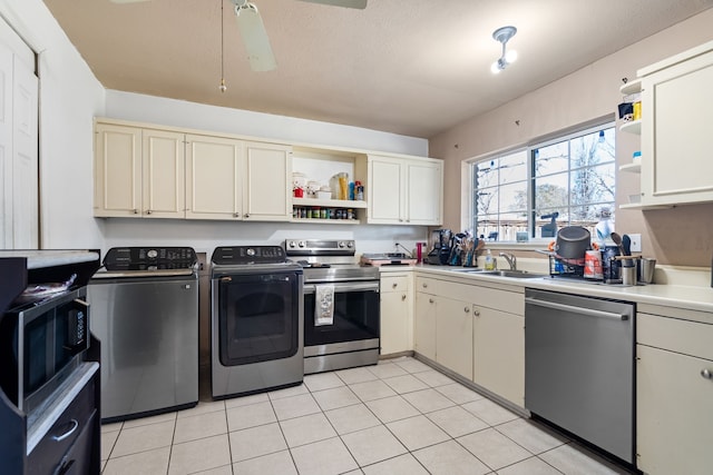 kitchen with sink, ceiling fan, stainless steel appliances, washing machine and dryer, and cream cabinets