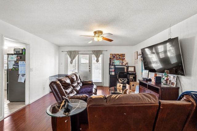 living room featuring ceiling fan, hardwood / wood-style floors, and a textured ceiling