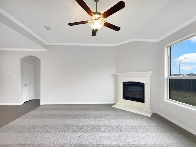 unfurnished living room featuring crown molding, a wealth of natural light, ceiling fan, and carpet flooring