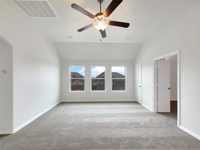 carpeted empty room with vaulted ceiling and ceiling fan