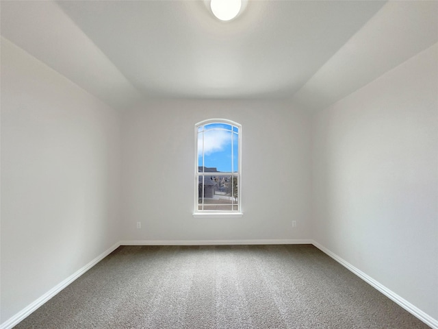 carpeted empty room with lofted ceiling