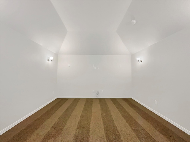 additional living space featuring vaulted ceiling and carpet floors