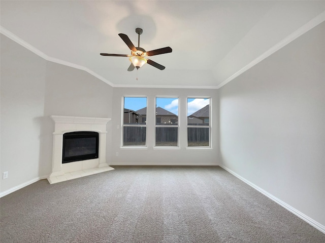 unfurnished living room with ceiling fan, ornamental molding, a tiled fireplace, and carpet