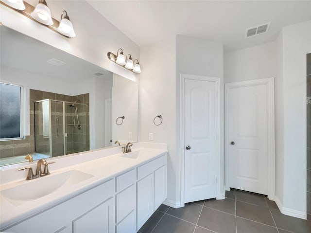 bathroom featuring tile patterned floors, a shower with shower door, and vanity