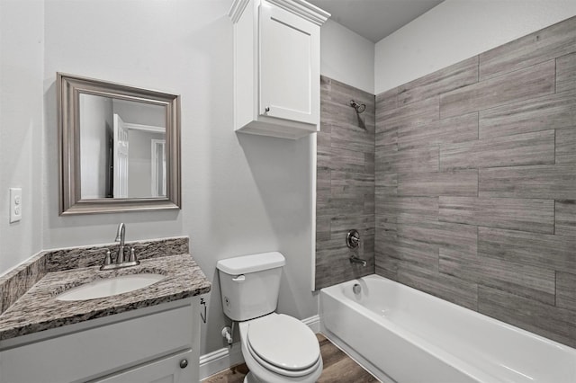 full bathroom with hardwood / wood-style floors, vanity, tiled shower / bath, and toilet