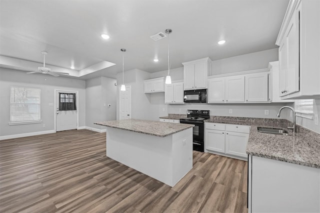 kitchen with white cabinetry, a kitchen island, sink, and black appliances