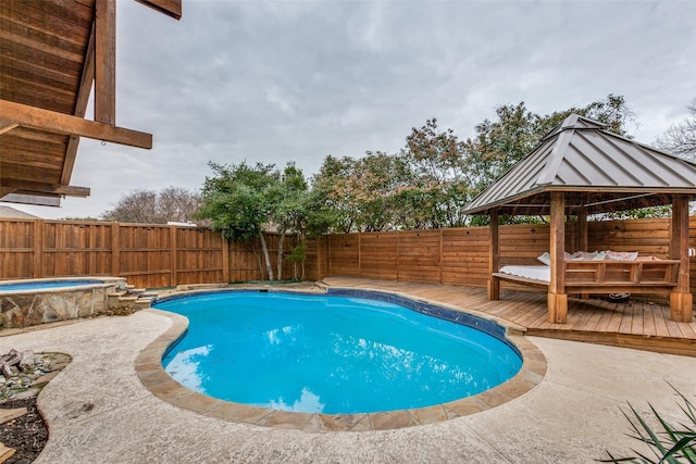 view of swimming pool featuring a wooden deck, a gazebo, and an in ground hot tub