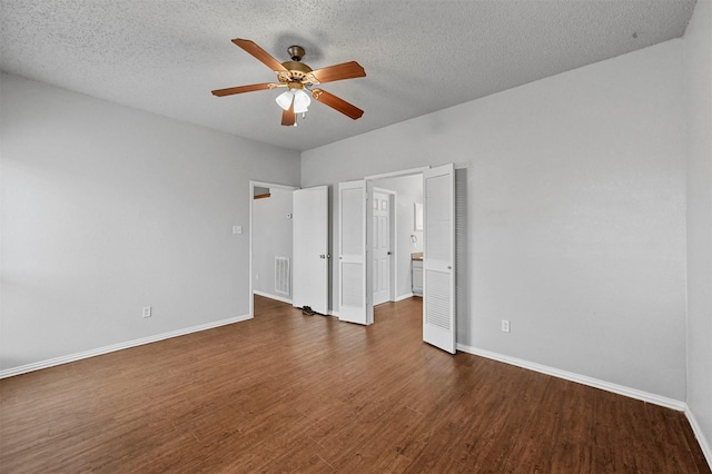 unfurnished bedroom featuring a textured ceiling, dark wood-type flooring, and ceiling fan