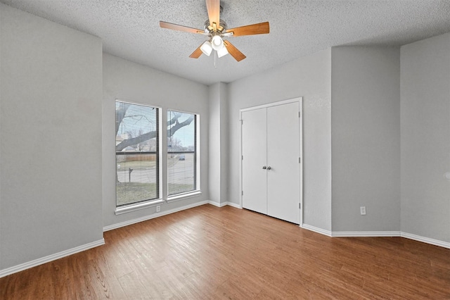 unfurnished bedroom with a textured ceiling, light hardwood / wood-style floors, and ceiling fan