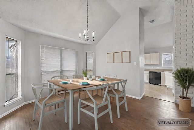 dining area with lofted ceiling, a wealth of natural light, and an inviting chandelier