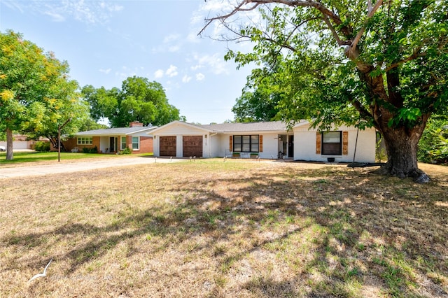 single story home featuring a garage and a front lawn