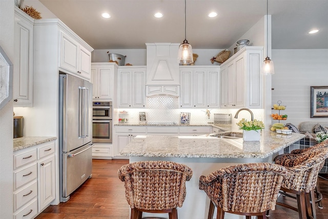 kitchen with stainless steel appliances, a kitchen breakfast bar, sink, and hanging light fixtures