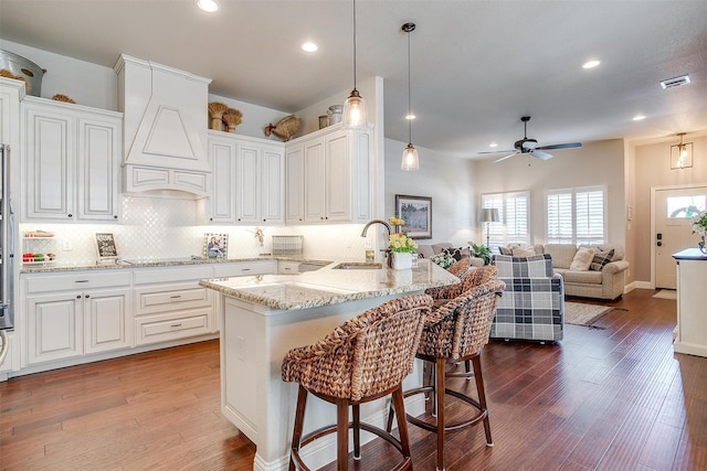 kitchen featuring kitchen peninsula, sink, and white cabinets