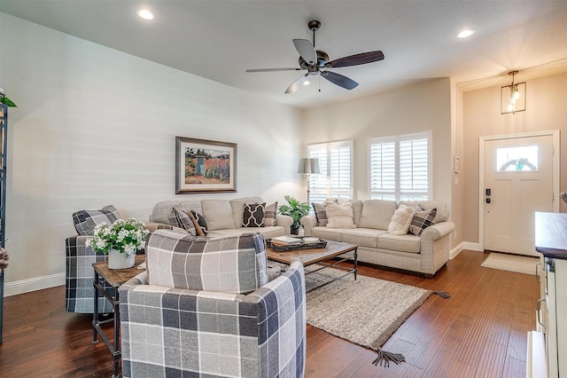 living room featuring dark wood-type flooring and ceiling fan