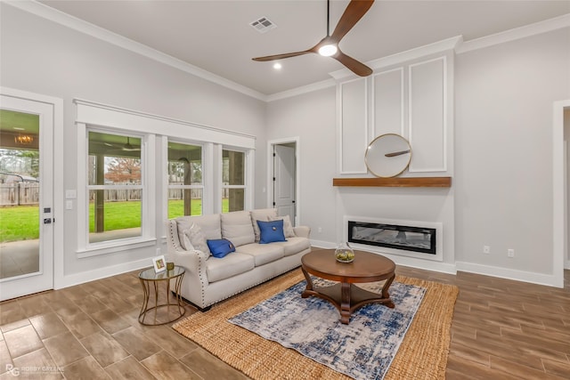 living room with ceiling fan and ornamental molding