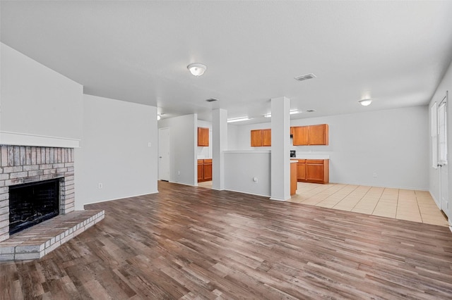 unfurnished living room with light hardwood / wood-style flooring and a fireplace