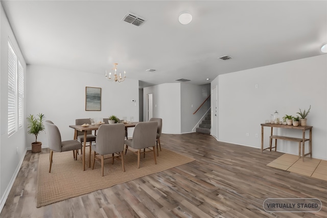 dining area featuring an inviting chandelier, hardwood / wood-style flooring, and a wealth of natural light