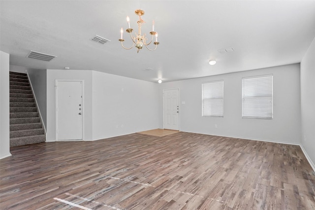 unfurnished living room with hardwood / wood-style floors and a notable chandelier