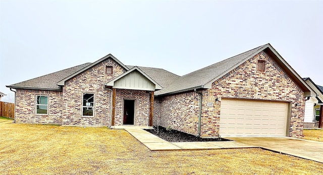 view of front of property with a garage and a front lawn