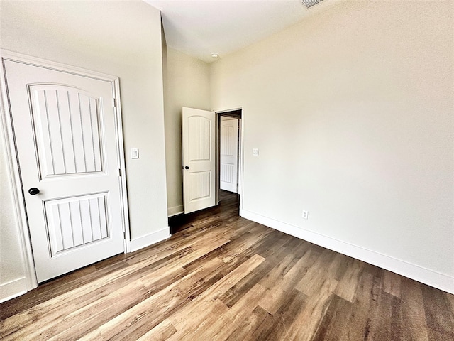 unfurnished bedroom with hardwood / wood-style floors and a closet