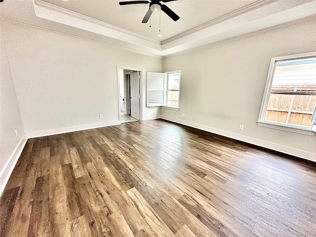 unfurnished room featuring ceiling fan, ornamental molding, a tray ceiling, and wood-type flooring