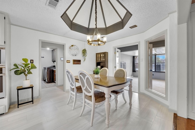 dining room with a notable chandelier and a textured ceiling