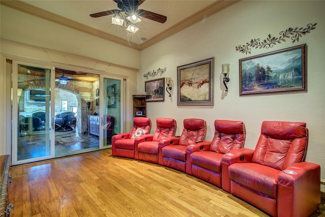 home theater room with crown molding, wood-type flooring, and ceiling fan