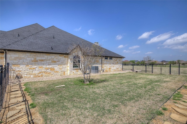 rear view of house with cooling unit and a yard