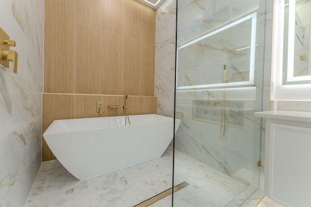 bathroom with vanity, separate shower and tub, and tile walls